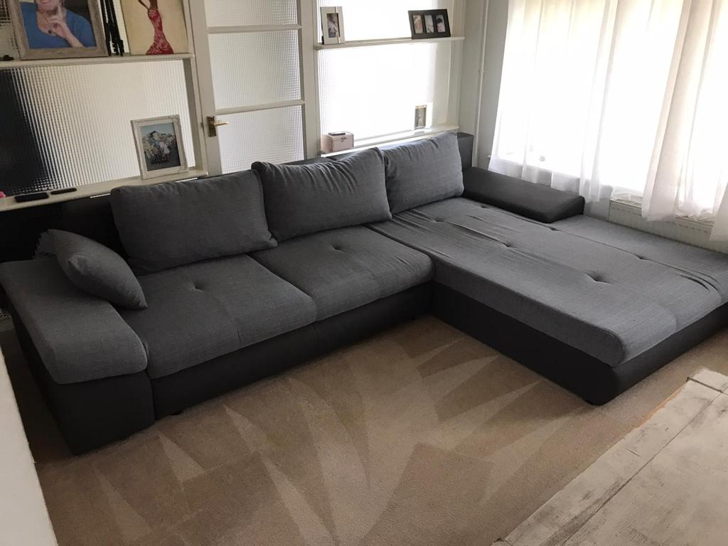 This is a photo of a grey L shape sofa that has been professionally steam cleaned, also the beige carpets have been steam cleaned too.